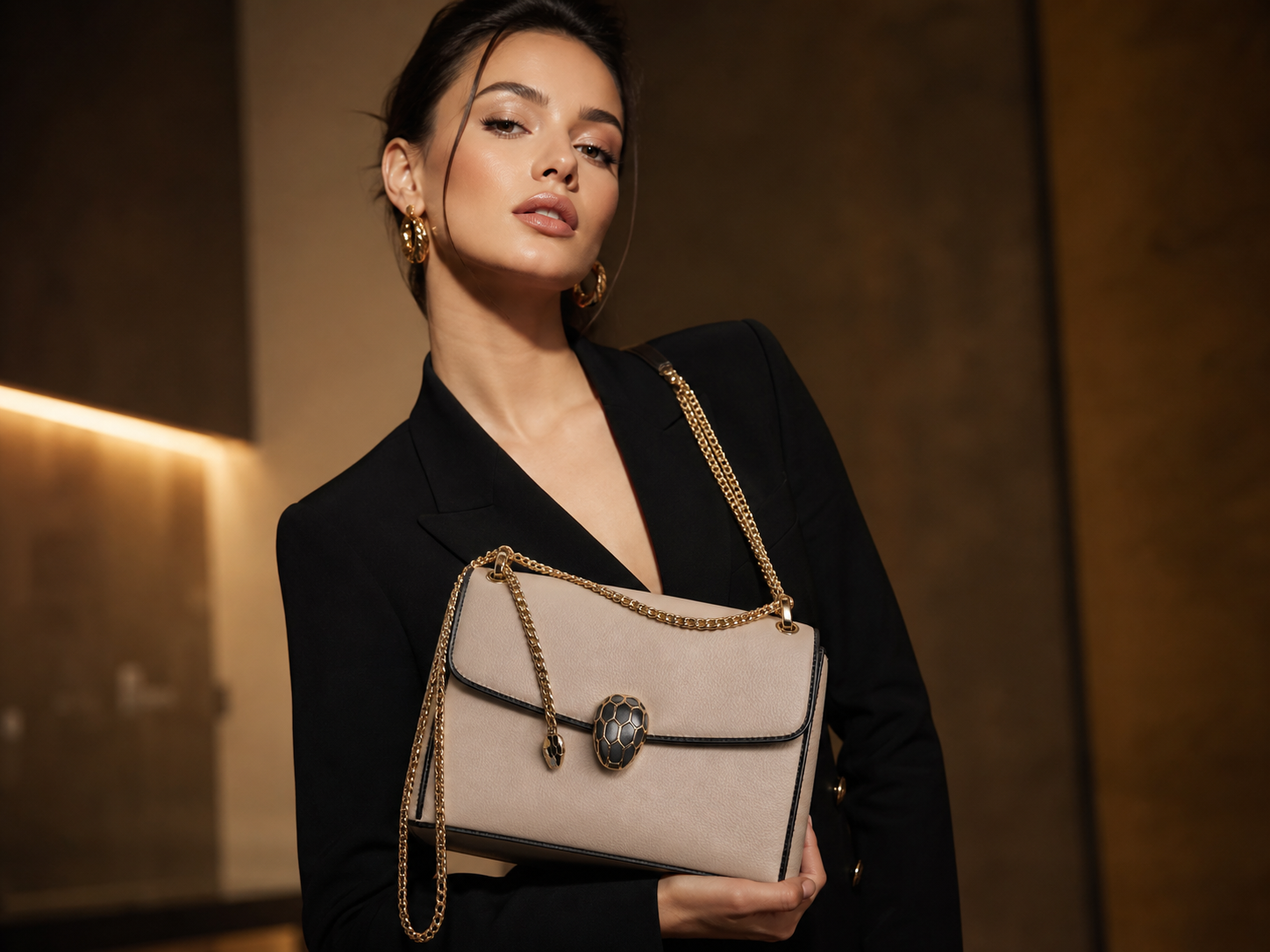 Woman holding a beige handbag with a decorative clasp in an indoor setting